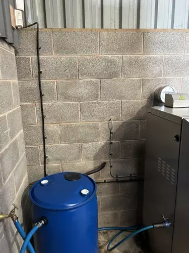 Water barrel and electrical supply installed to feed a Nilfisk SH Truck static hot pressure washer inside a farm wash bay in Twycross.